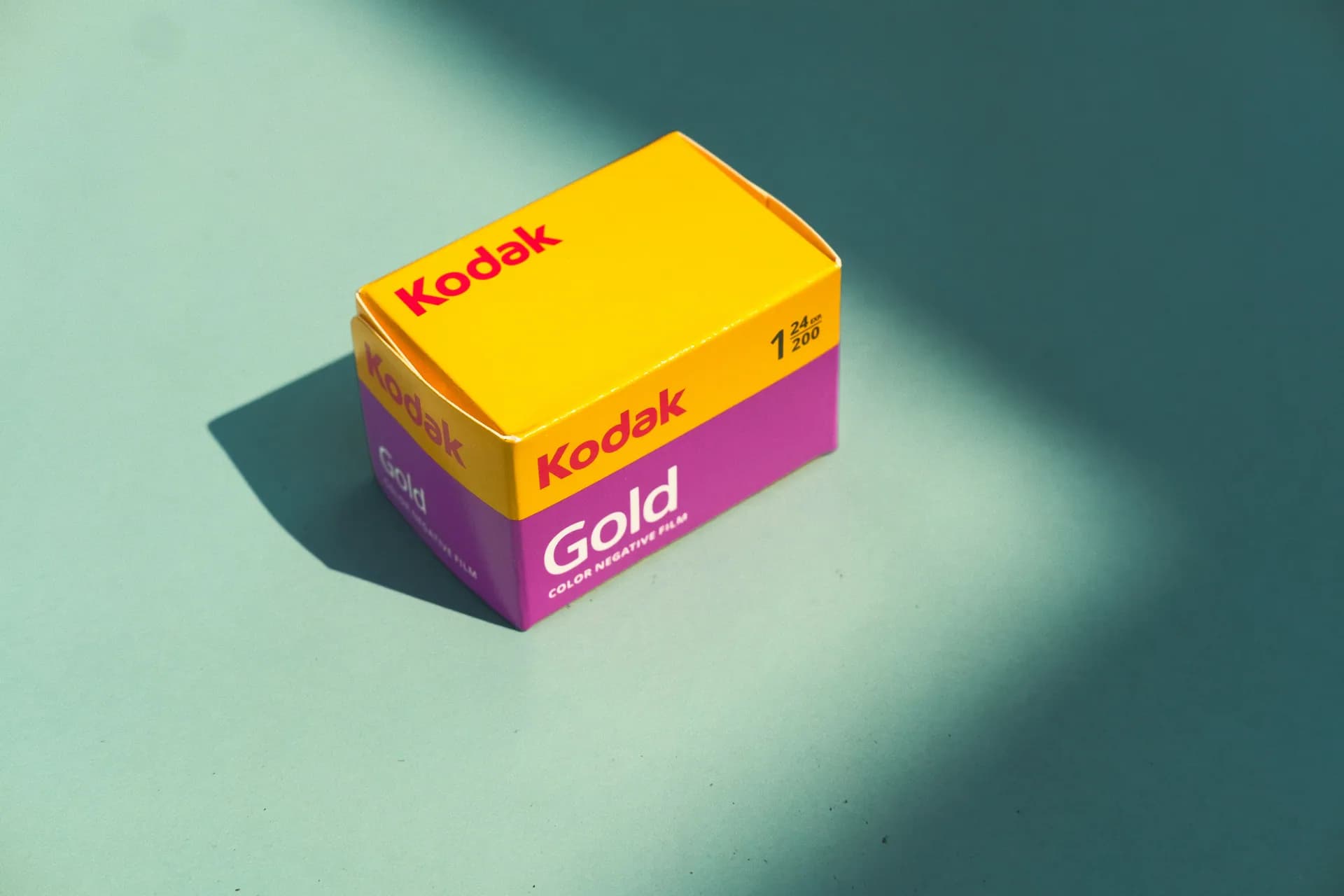 Product photo of a Kodak Gold film box lit with dramatic shadow